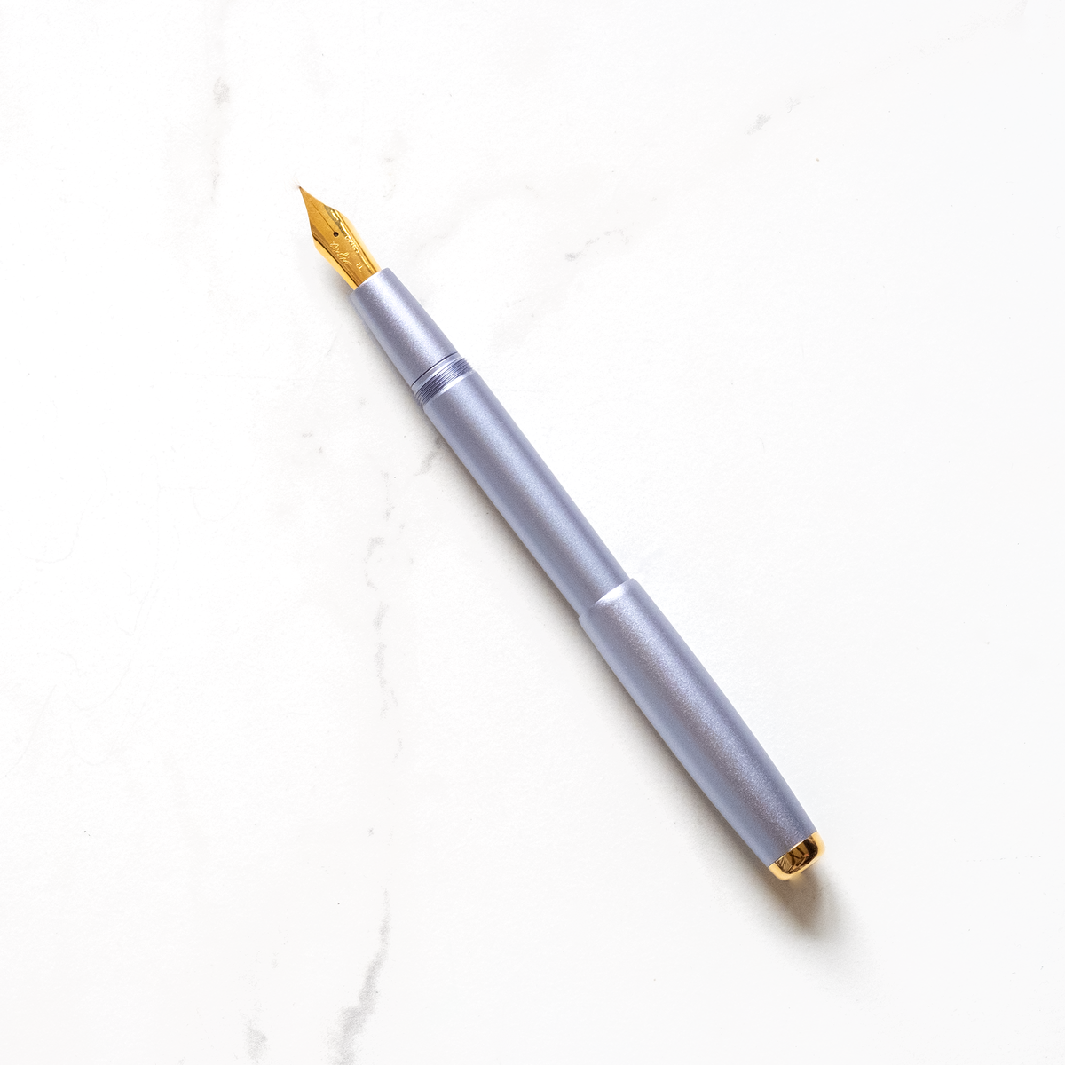 Lilac fountain pen with gold nib and clip, shown uncapped.