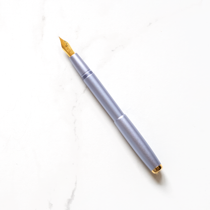 Lilac fountain pen with gold nib and clip, shown uncapped.