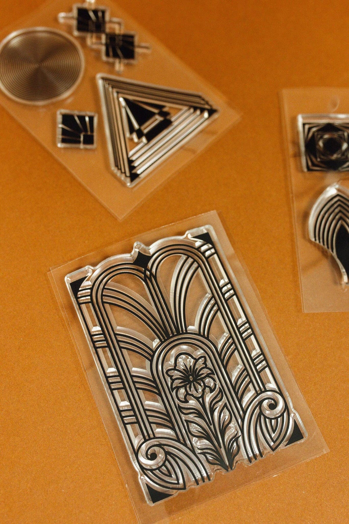Clear art deco stamp set with ornate arch, triangle, and spiral motifs in sleeves