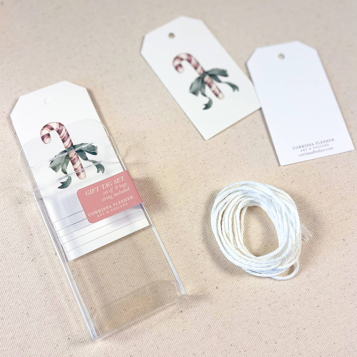 Set of gift tags with candy cane and holly icons, with white string spool