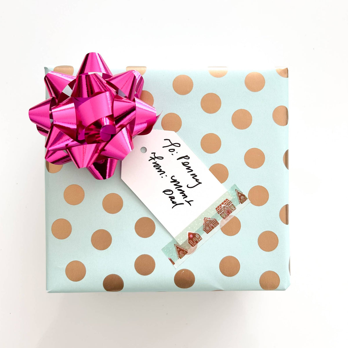 Washi tape on light blue wrapping with orange polka dots and pink ribbon