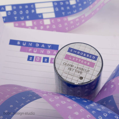 Embossed letters kiss-cut PET tape roll, clear backing with blue and lavender letter set