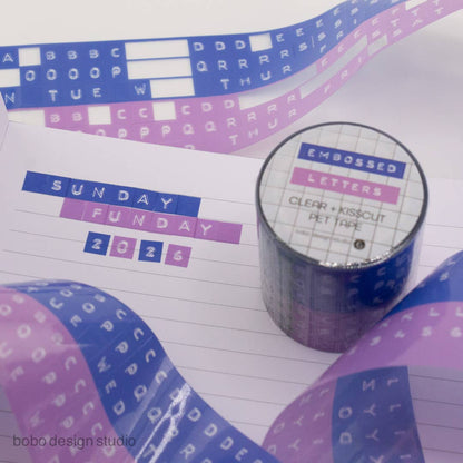 Embossed letters PET tape roll with clear backing and blue and lavender letter strips