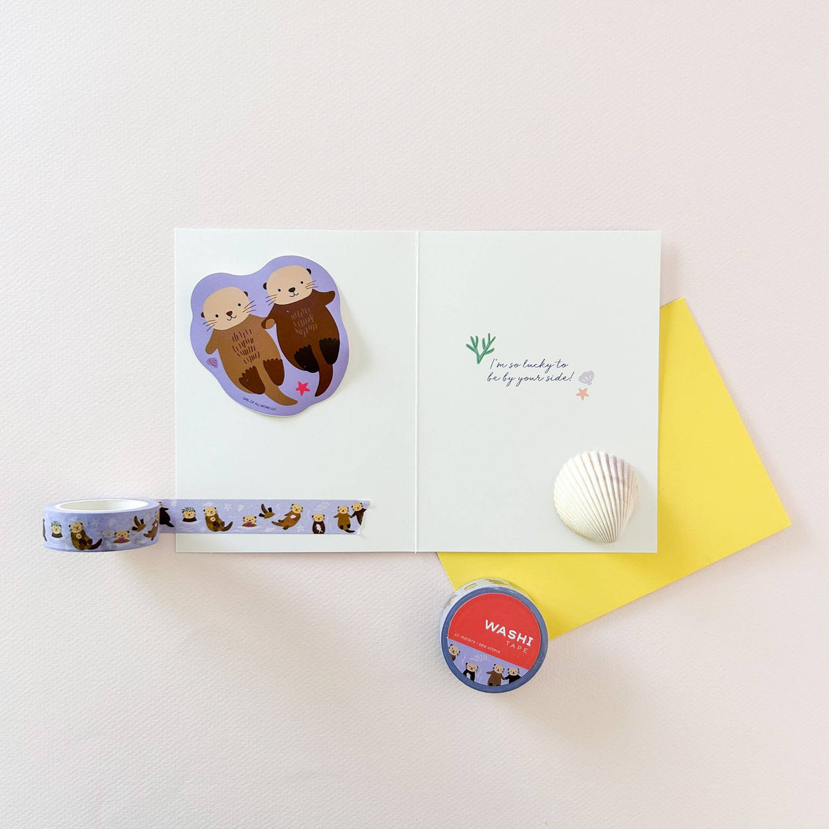 Sea otters vinyl sticker on a card, featuring two otters and a pink star