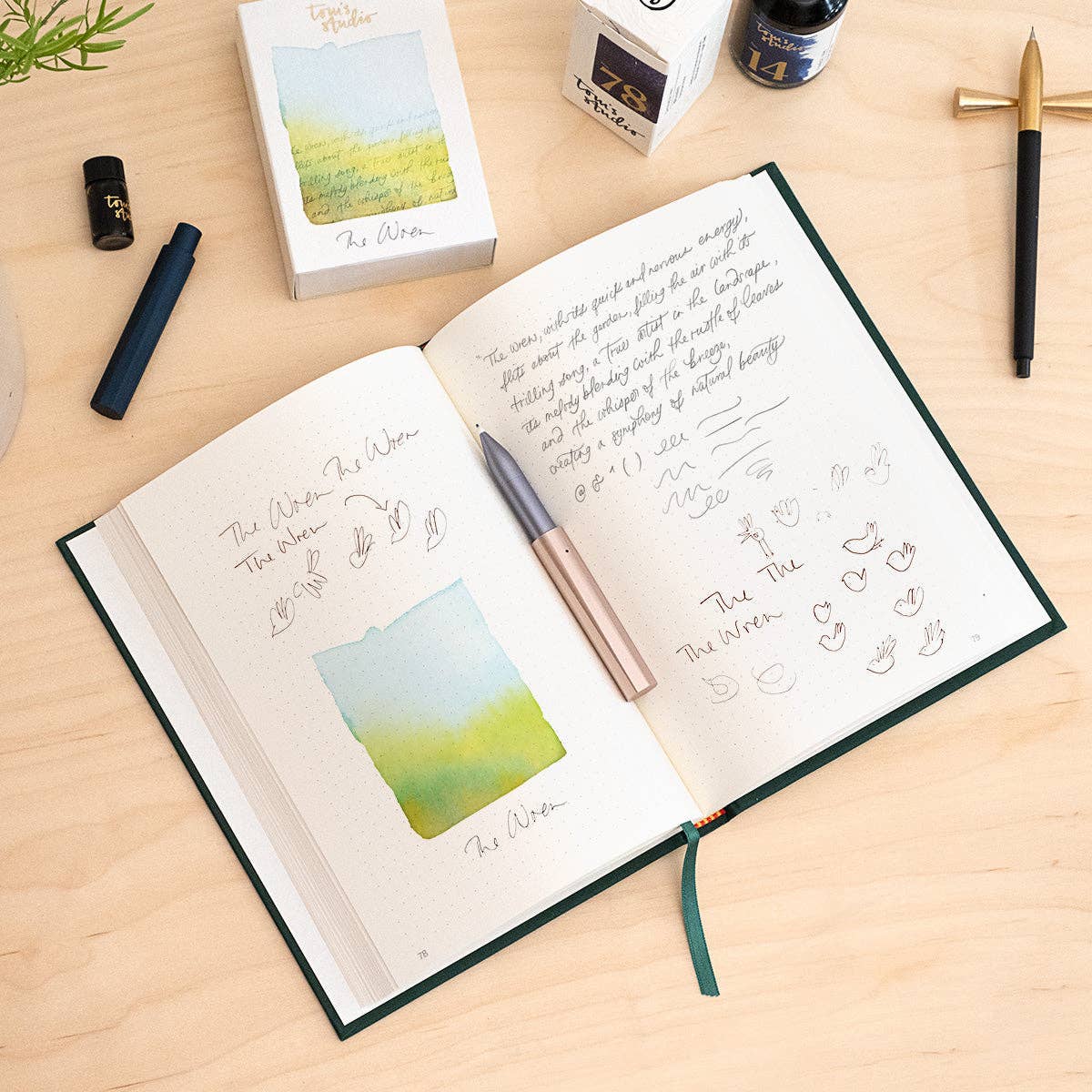 Refillable writing pen, rose-gold barrel with nib tip over an open notebook
