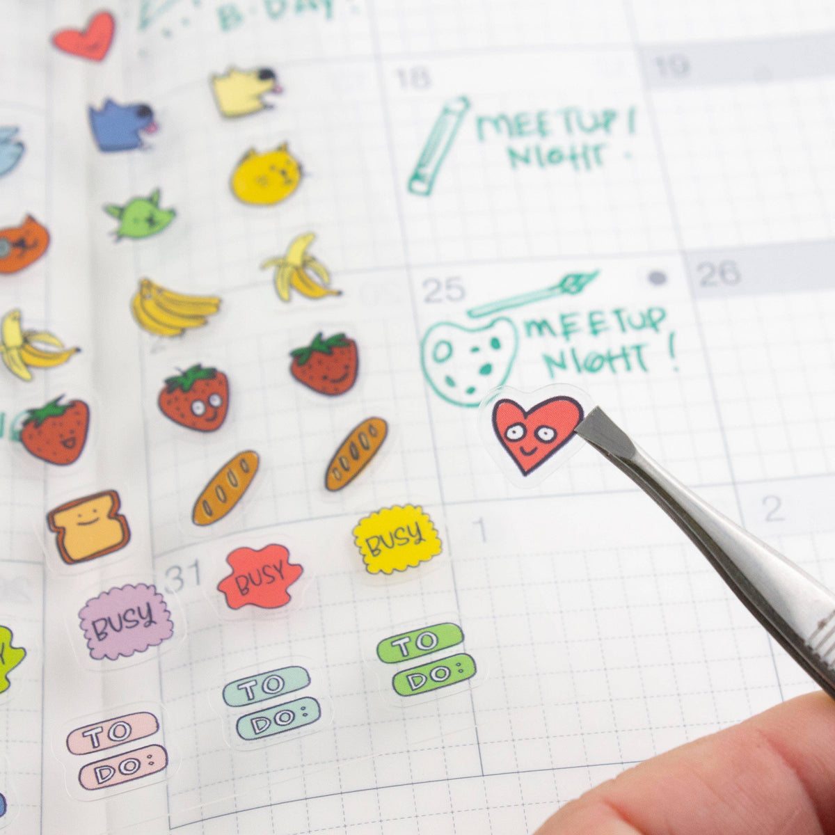 Clear planner stickers with dates, pencil notes, meeting text, and cat and banana icons
