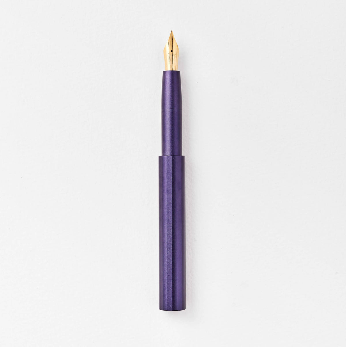Dark purple pocket fountain pen with gold nib, uncapped.