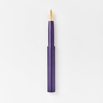 Dark purple pocket fountain pen with gold nib, uncapped.