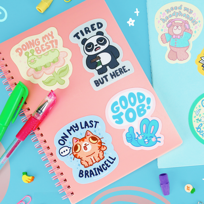 Set of colorful vinyl stickers on notebook: panda, rabbit, and braincell cat