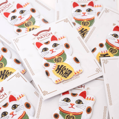 Lucky cat iron-on patches on multiple cards, white cat with red hat and gold coin