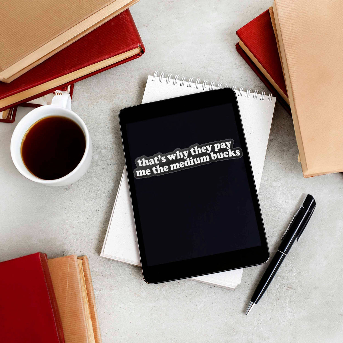 Funny quote sticker on black tablet: 'that's why they pay me the medium bucks'