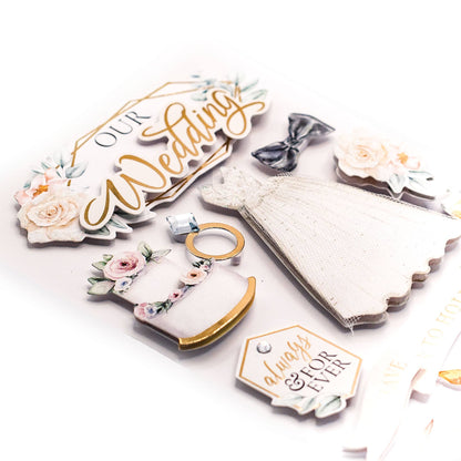 3D wedding stickers laid out: Our Wedding sign, lace dress, rings, and flowers