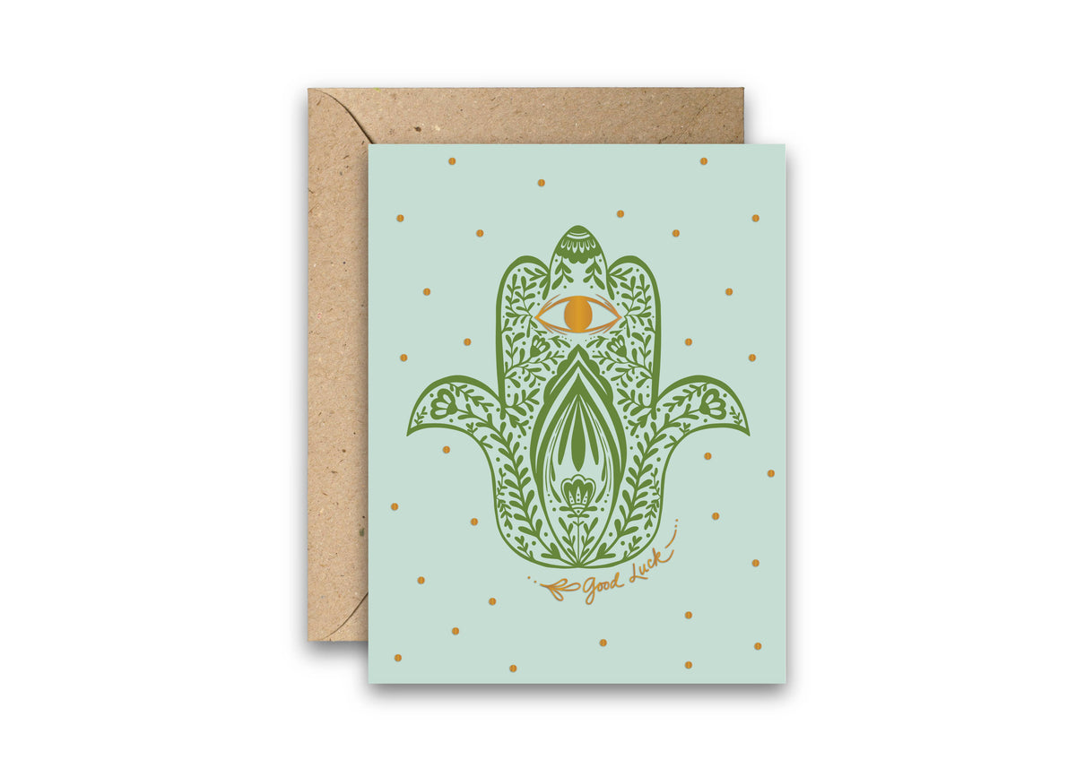 Good luck greeting card with a green hamsa hand, gold foil details, and kraft envelope
