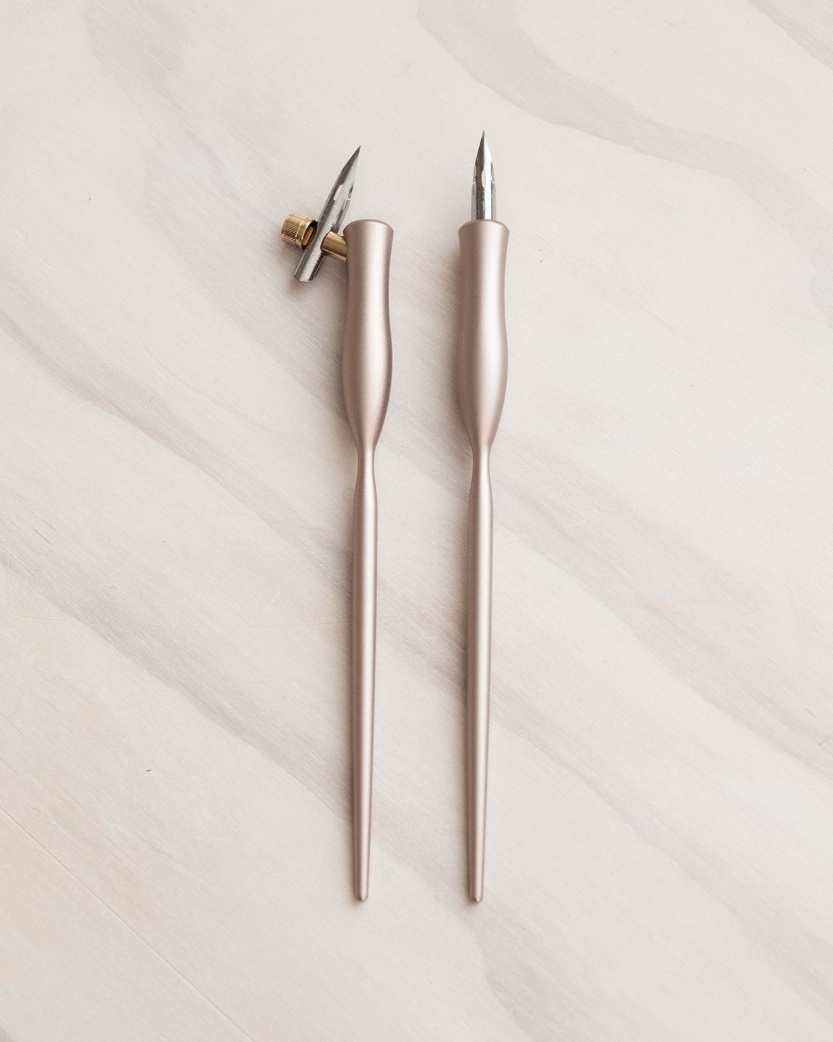 Flourish calligraphy pens with rose-gold and pale rose bodies, gold nibs