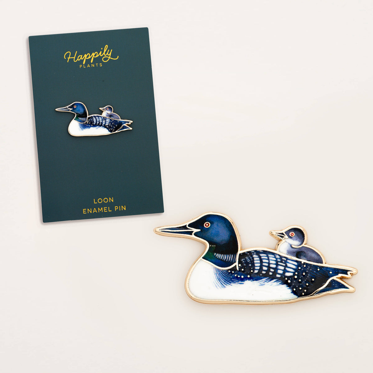 Loon enamel bird pin with blue head, striped body, and gold-tone edges