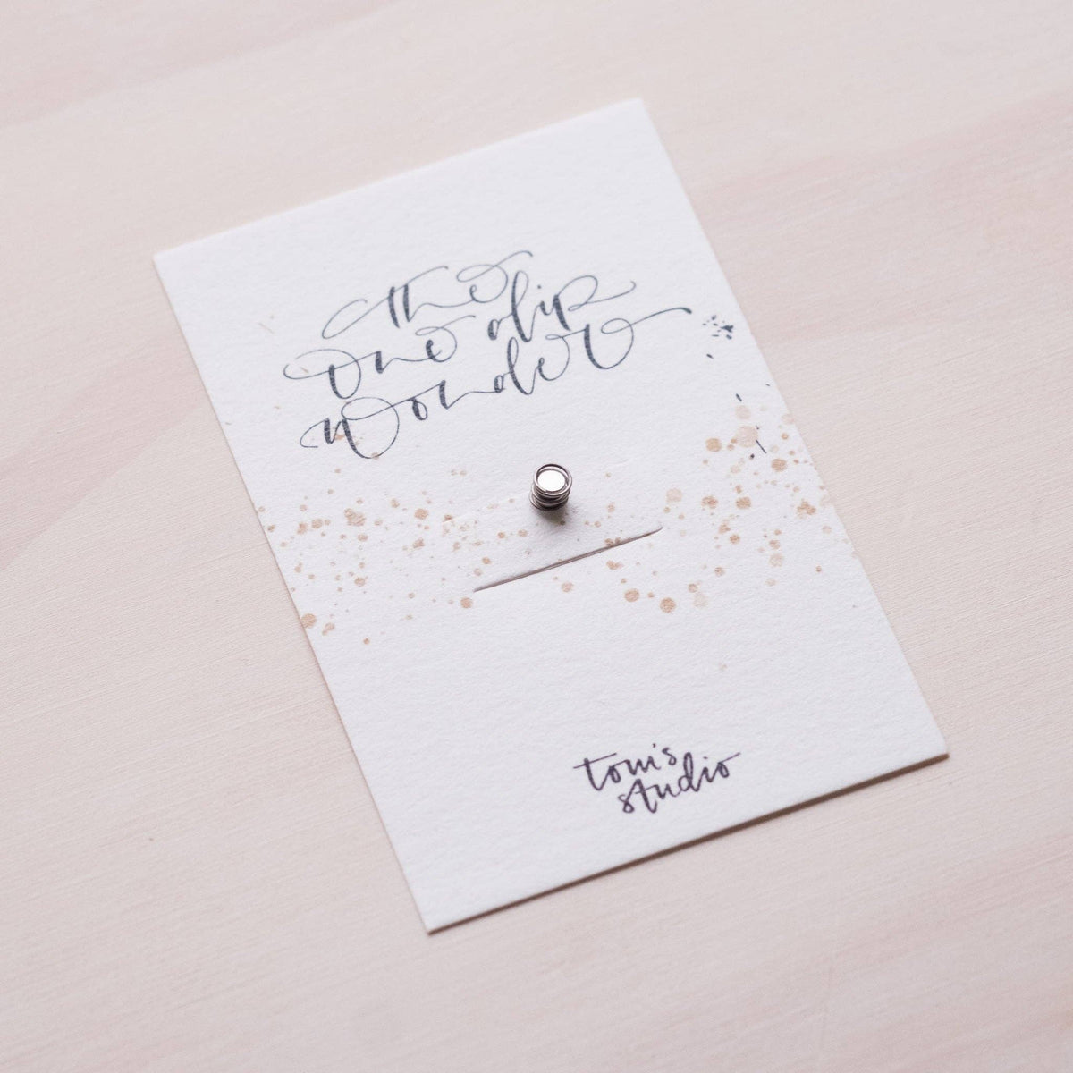 One Dip Wonder card insert with handwritten text and small metal snap pin