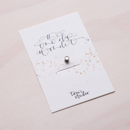 One Dip Wonder card insert with handwritten text and small metal snap pin