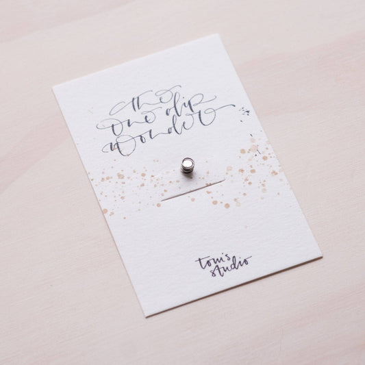 One Dip Wonder card insert with handwritten text and small metal snap pin