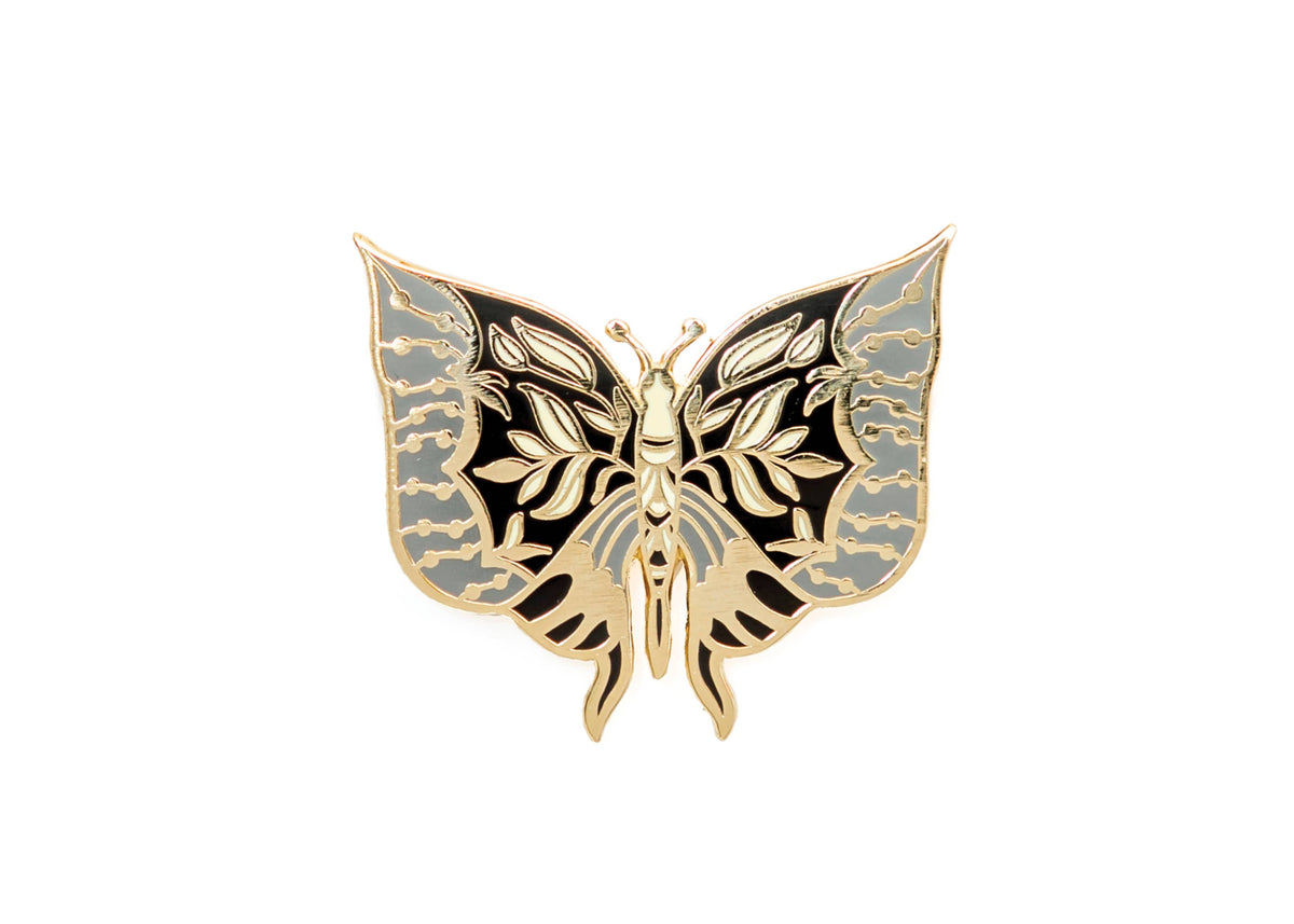 Moth enamel pin with symmetrical pale blue, black, and gold wings.