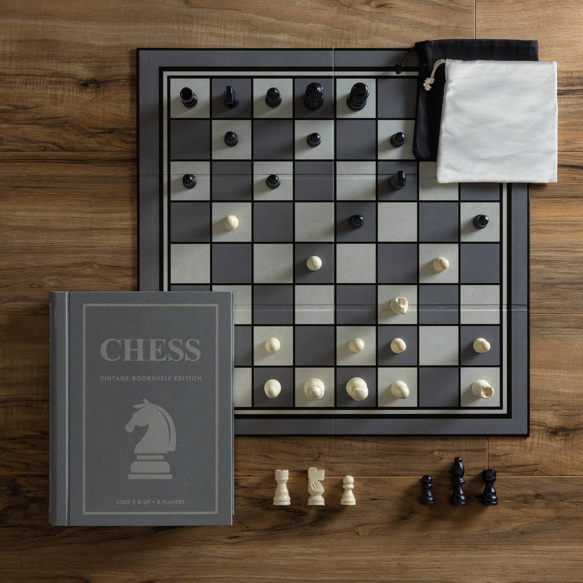 Chess game set with checkered board, pieces, and vintage CHESS bookshelf edition book