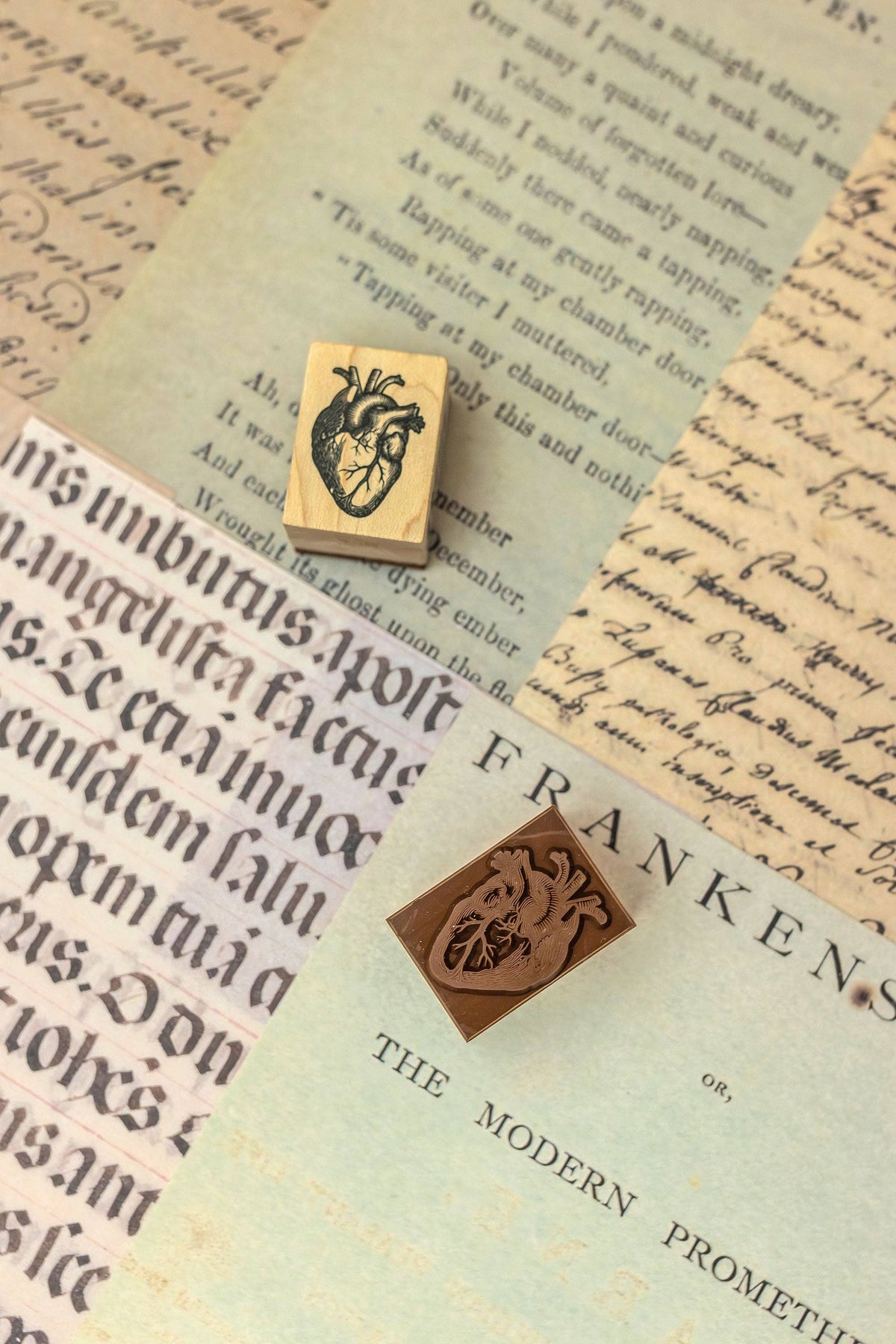 Two wooden stamp blocks with carved crest designs on vintage-style paper