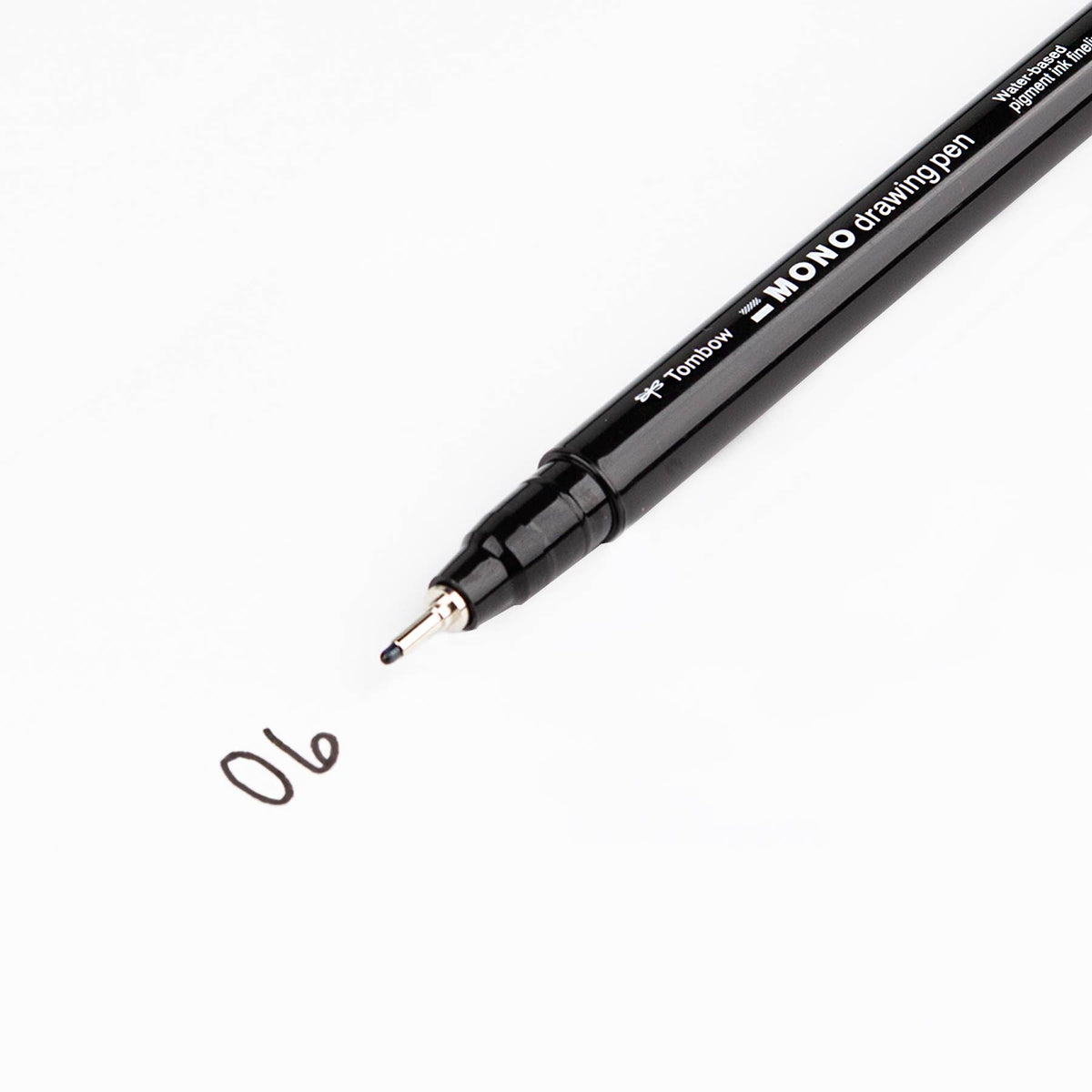 Black MONO drawing pen with fine metal tip, numbered ink mark 06 on a white surface
