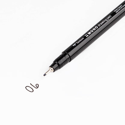 Black MONO drawing pen with fine metal tip, numbered ink mark 06 on a white surface