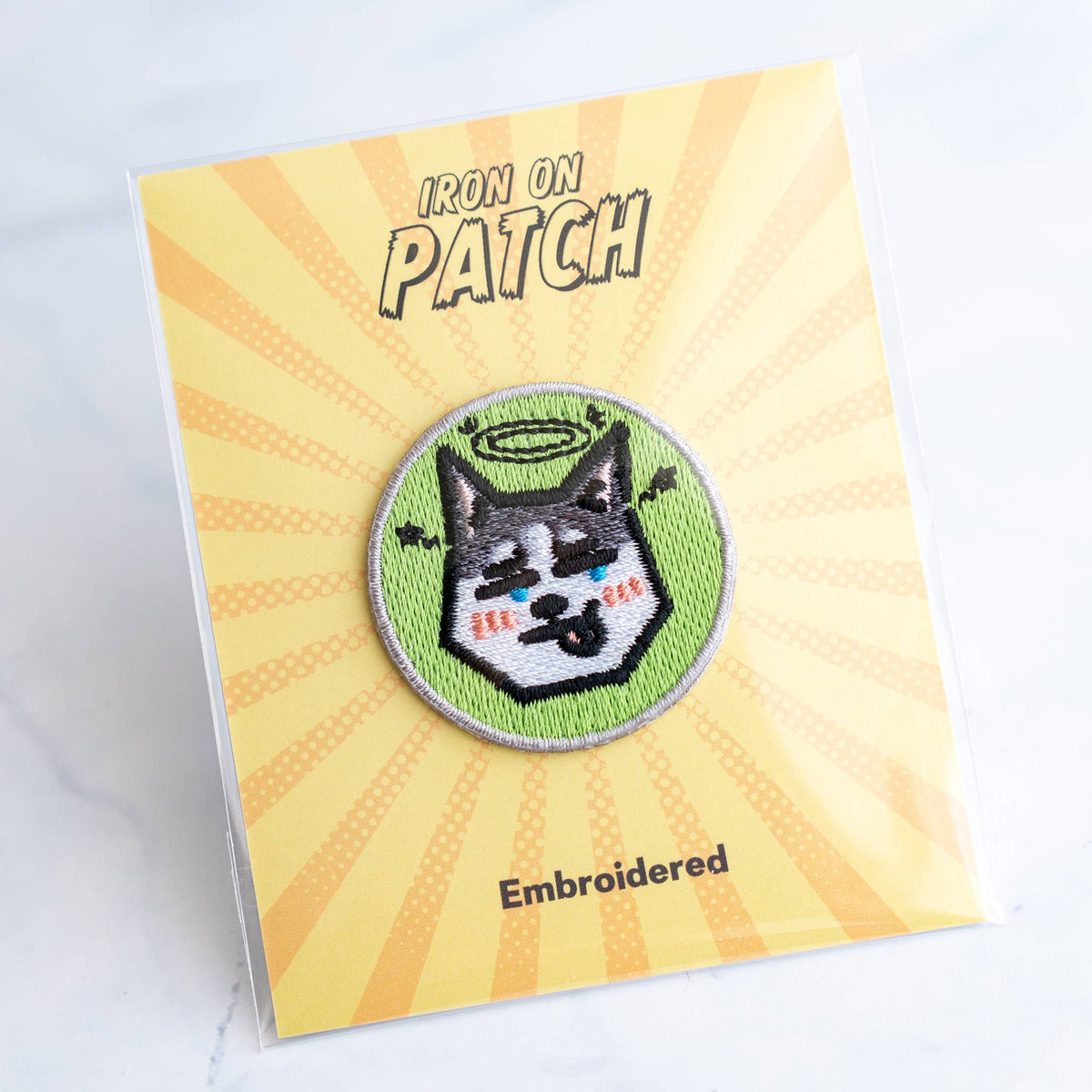 Round embroidered dog iron-on patch with black-and-white dog face on green