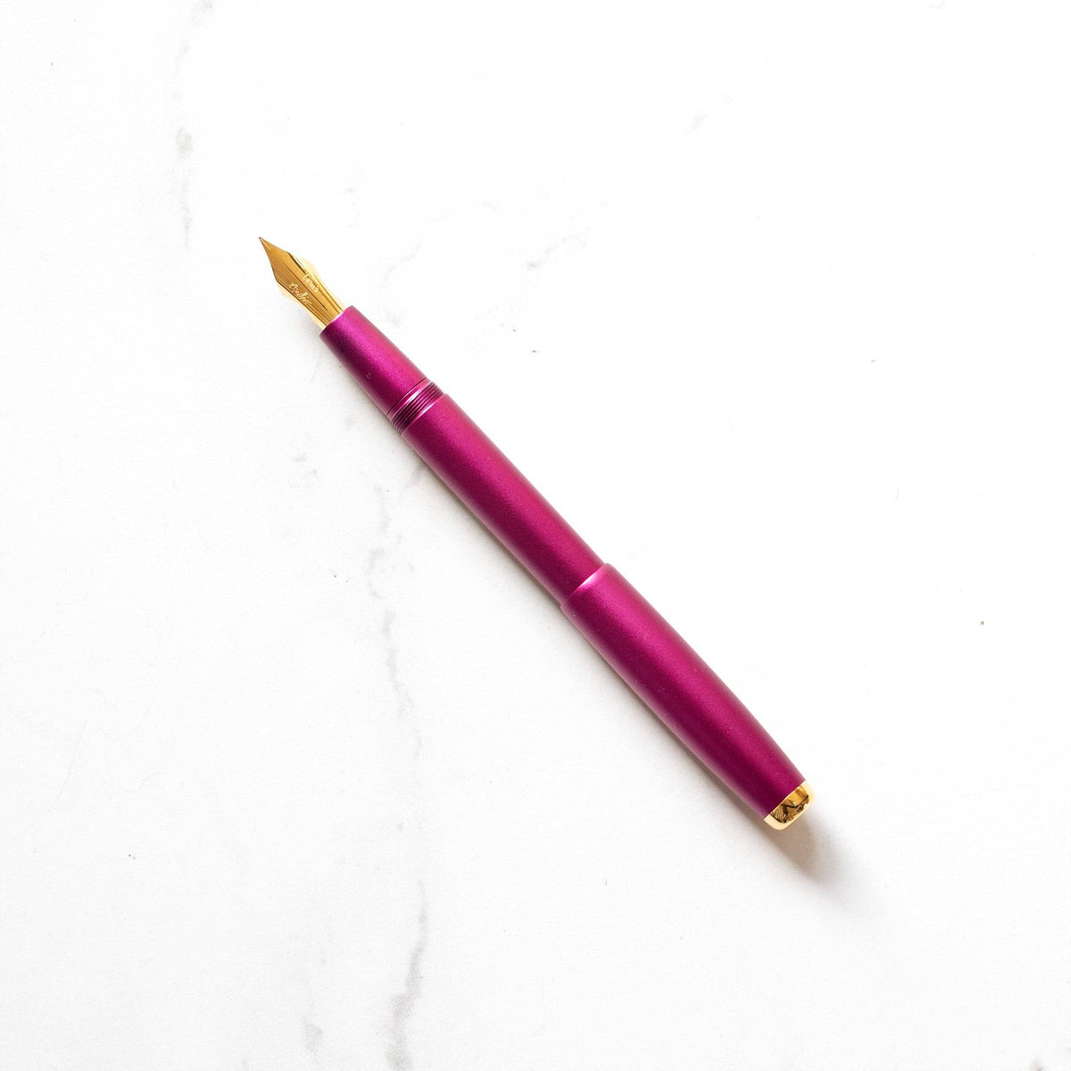 Fountain pen with magenta barrel and gold nib