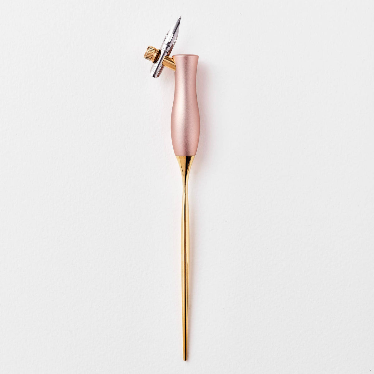 Pink calligraphy pen with oblique nib and gold accents, upright close-up