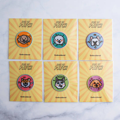 Six round embroidered dog iron-on patches in a grid on yellow cards