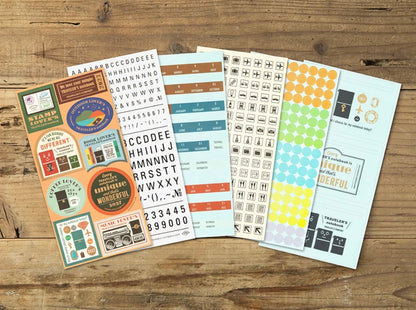 Assorted sticker sheets for a 2027 notebook diary, featuring badges, labels, and alphabet designs