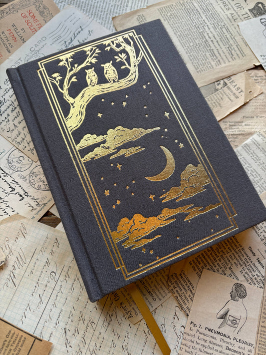 Black B6 paper notebook with gold moon and tree illustration on the cover