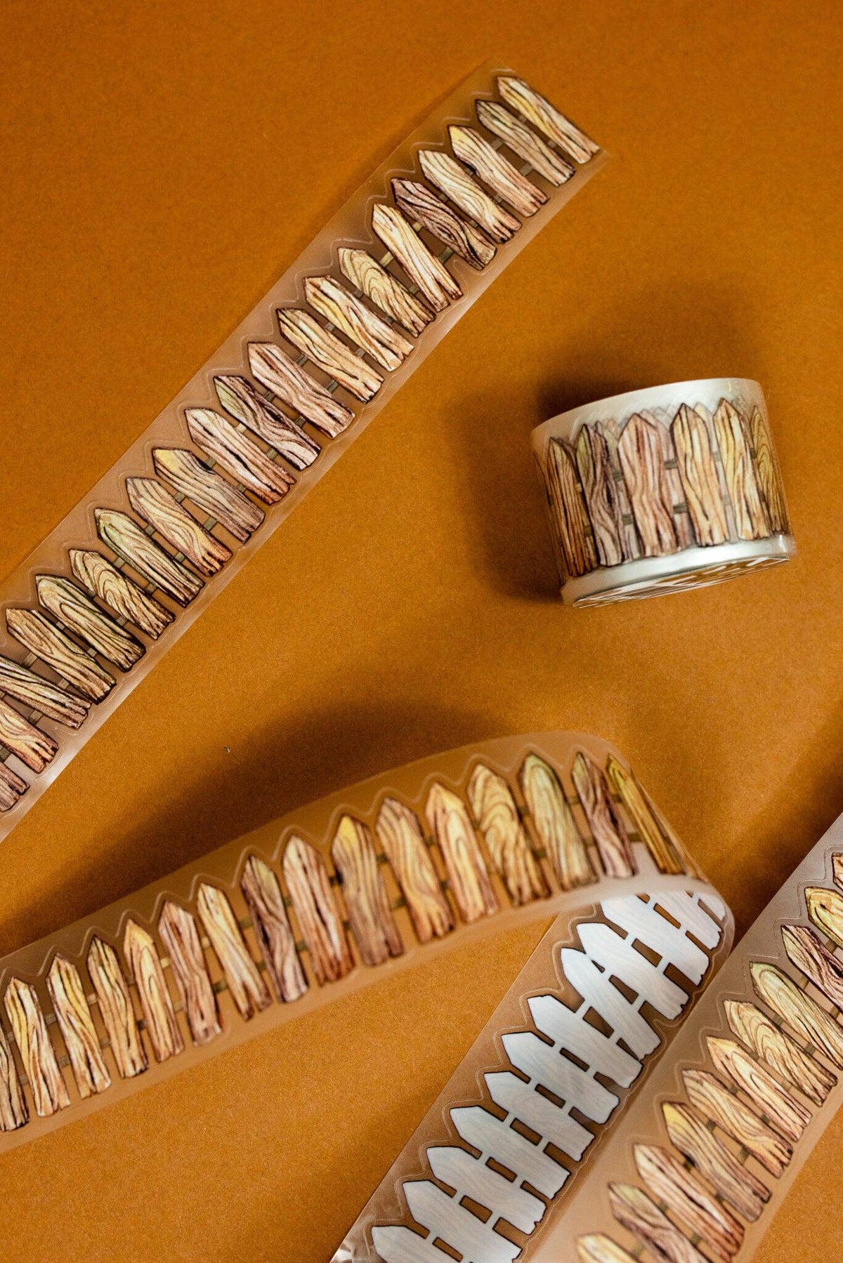 Transparent wooden fence tape roll with clear backing and brown bristle-like edge