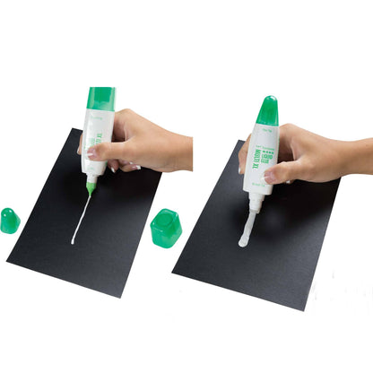 Person dispensing dual-tip liquid glue from squeeze bottle onto paper
