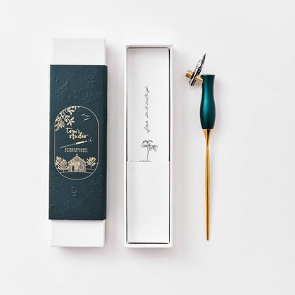Calligraphy pen with oblique nib, teal handle and gold barrel, shown with gift box