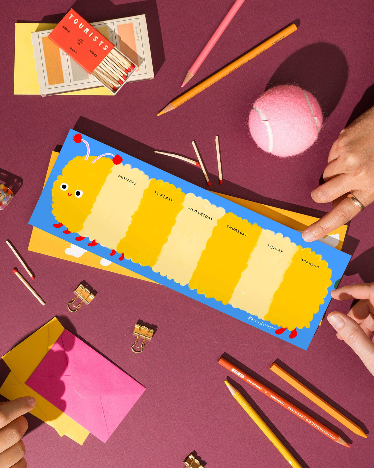 Caterpillar weekly desk planner pad with yellow and cream day panels and a blue border