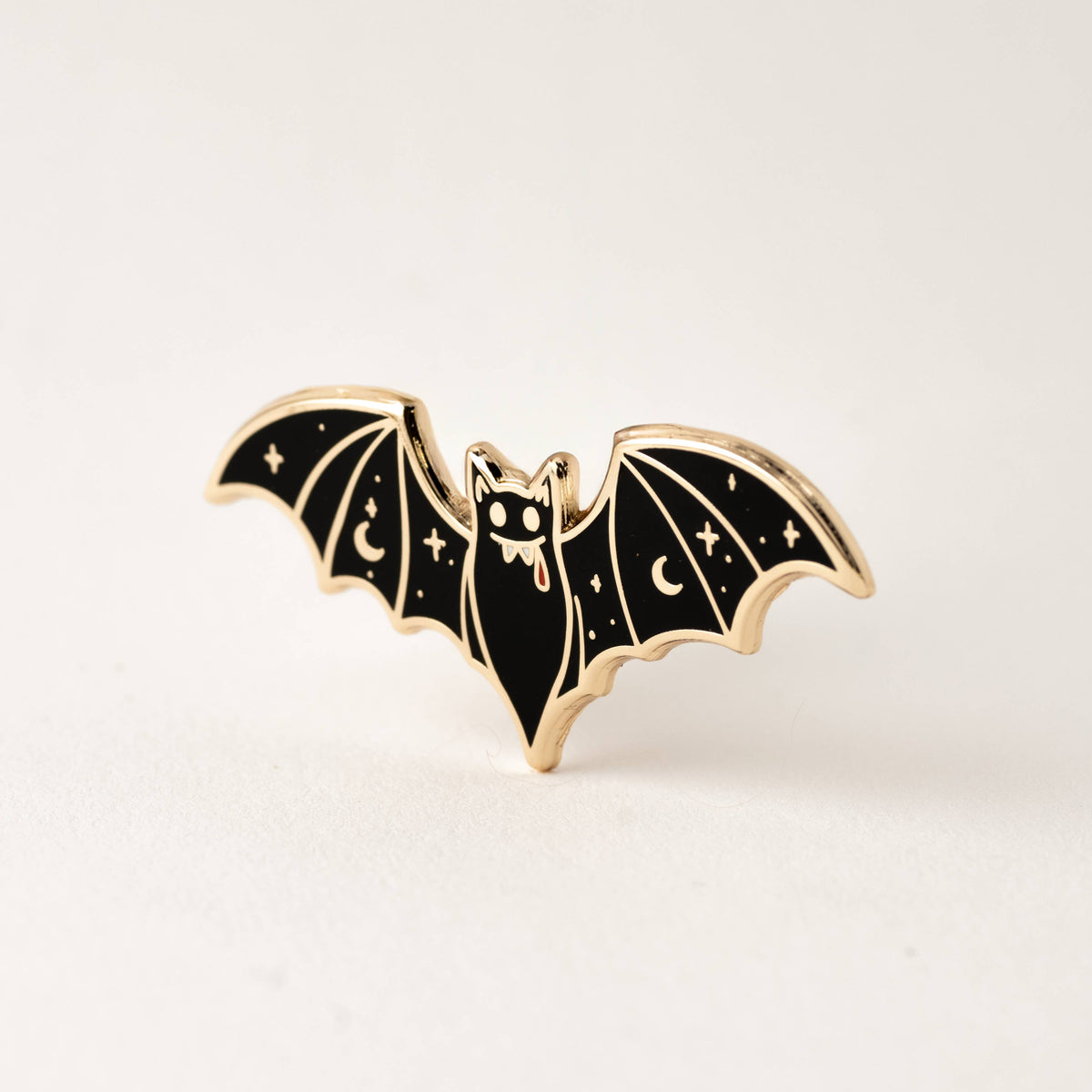 Vampire bat enamel lapel pin, gold-tone edging, black wings with moon and stars