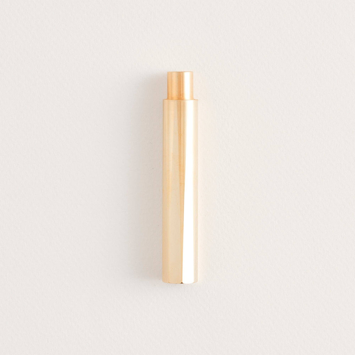 Brass refillable writing pen, cylindrical body with copper-toned tip.
