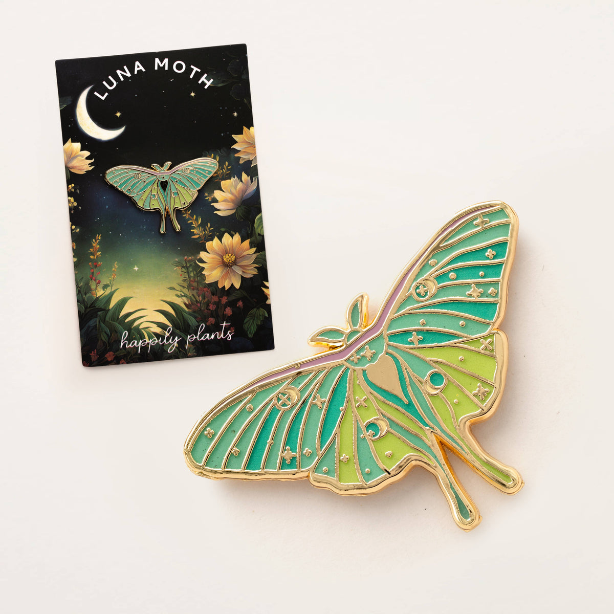 Enamel luna moth pin with green wings and gold border, shown on Happy Plants card