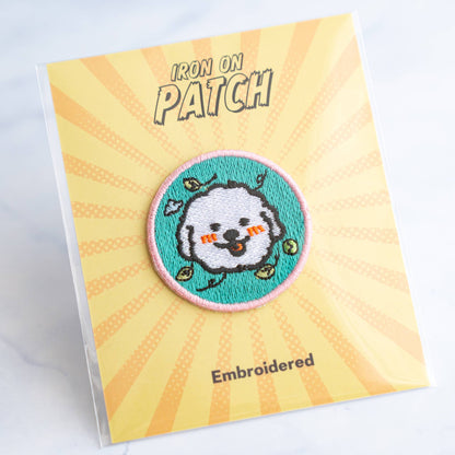 Round embroidered dog iron-on patch with gray dog face on teal with hearts