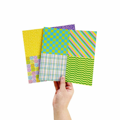 Hand holding four patterned paper sheets: smiley, checkered, stripe, and checker waves