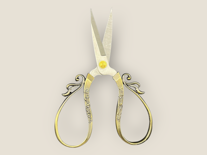 Large cutting scissors, gold-tone ornate handles and pointed blades