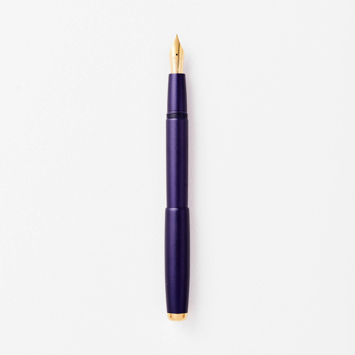 Purple fountain pen with gold nib and clip, shown uncapped.