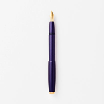 Purple fountain pen with gold nib and clip, shown uncapped.
