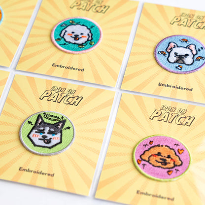 Close-up of four round embroidered dog iron-on patches on yellow cards