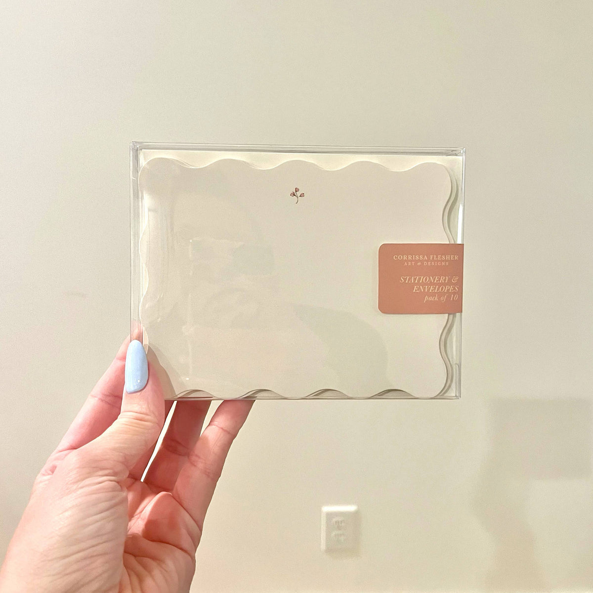 Clear sleeve with cream envelopes and a small floral motif on the front