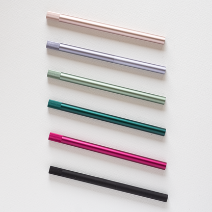 Assorted refillable multi-tip pens laid out in pink, teal, green, and black