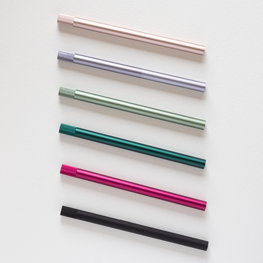 Assorted refillable multi-tip pens laid out in pink, teal, green, and black