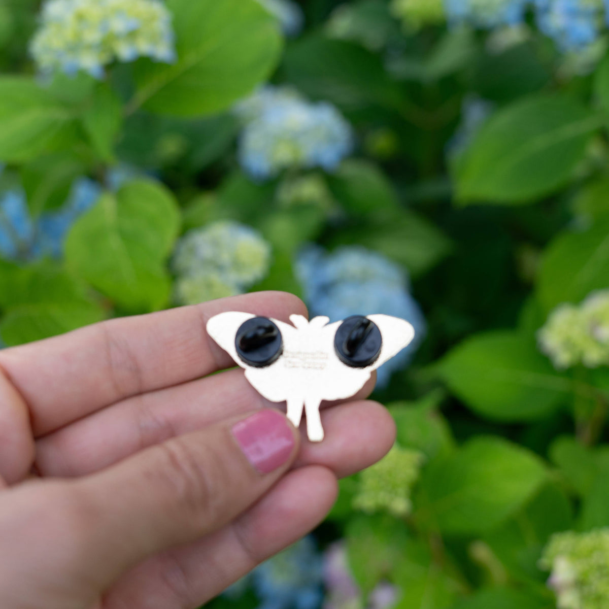White enamel moth pin with black wings and small body detail